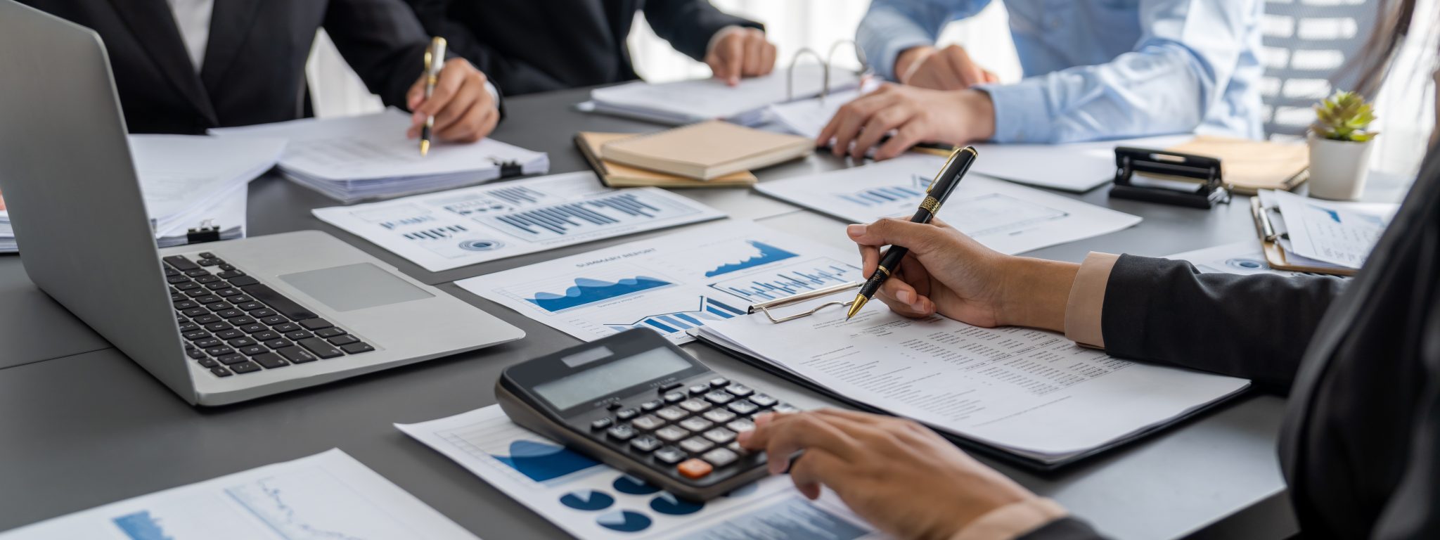 Business professionals working around a table, analyzing financial data